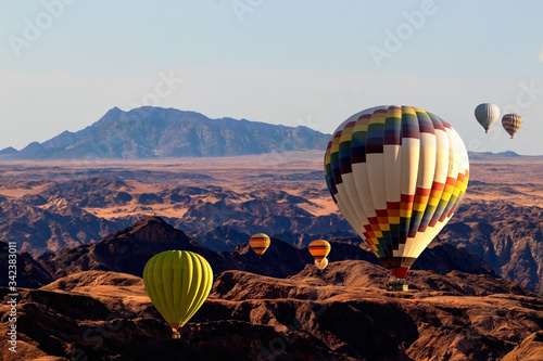 Colorful hot air balloons flying over the moon valley mountain. Africa. Namibia.