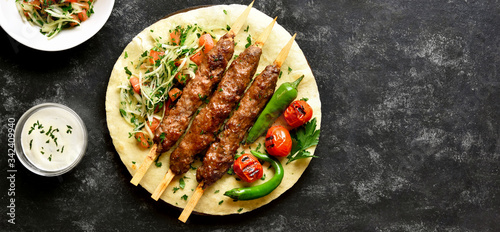 Adana Kebab with fresh vegetables on flatbread