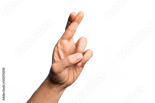 Hand of caucasian young man showing fingers over isolated white background gesturing fingers crossed, superstition and lucky gesture, lucky and hope expression