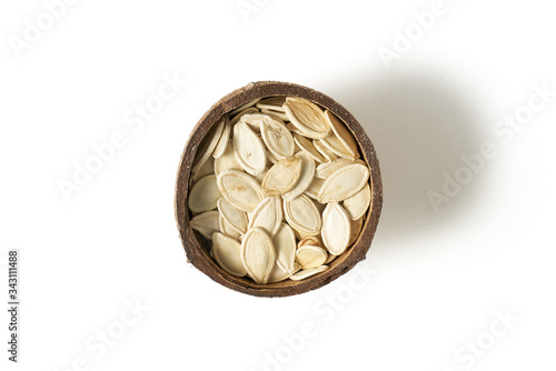Pumpkin grains in small bowls with coconut on a white background