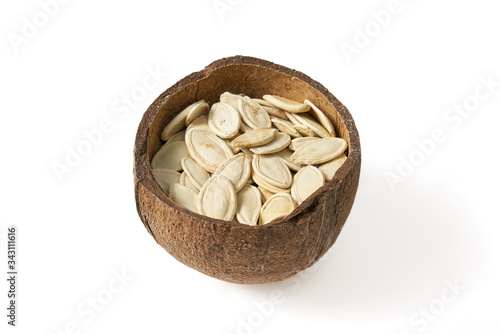 Pumpkin grains in small bowls with coconut on a white background