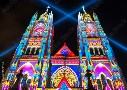 The neo - gothic style Basilica of the National Vow (Basilica del Voto Nacional) illuminated with colorful lights during the Quito light festival.