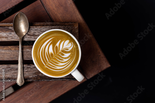 White cup of latte art barista cappuccino on a wooden table