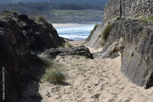 sand path neare a stone wall at castro de baroña