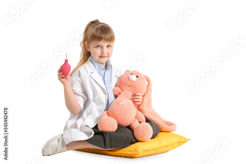 Cute little doctor with toy on white background