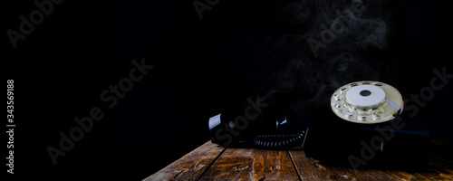 Vintage black dial phone on dark background