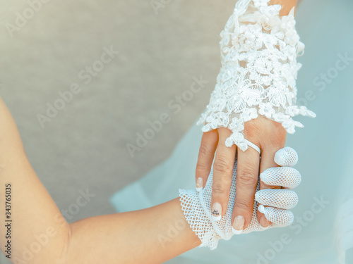 Main de la mariée et de son enfant le jour du mariage. Gants en dentelle et manucure pour la cérémonie de mariage