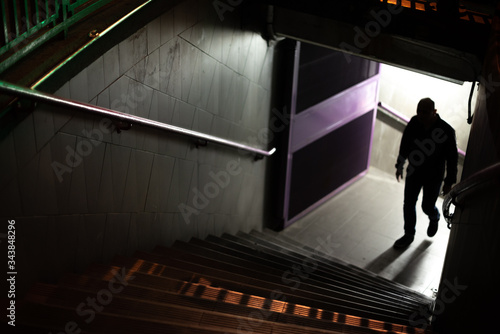 Silhouette of a suspicious man. Man up the stairs of the subway.