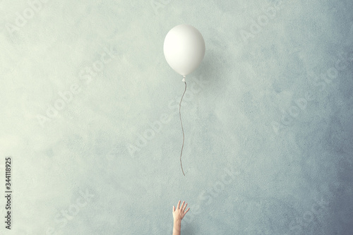 hand lets white balloon fly free