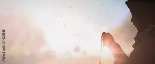 Young muslim woman prayer with hijab pray to God on blur mosque background concept for eid mubarak, life and soul fasting of international islamic ramadan sunlight