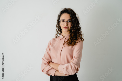 Chica maquillada y elegante con camisa y con los brazos cruzados, pose corporativo