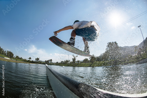 Wakeboarder jumps at ramp at wake park