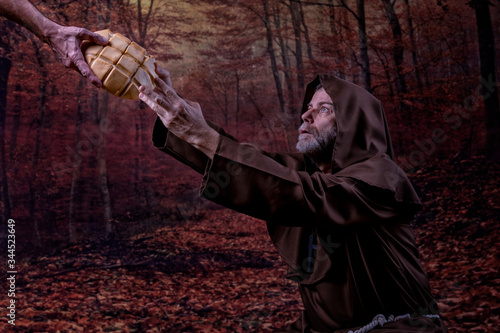 Friar, kneeling in a forest, receiving a loaf of bread