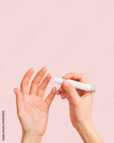 Close-up hands and lancet for glucose blood sample