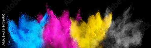 colorful CMYK cyan magenta yellow key holi paint color powder explosion isolated dark black background. printing print business industry manufacturing beautiful party festival concept