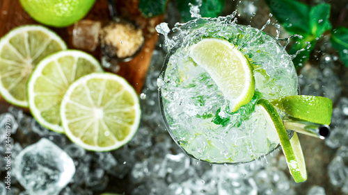 Top view shot of fresh mojito cocktail with fresh lime and mint leaf on black stone background, Freeze motion