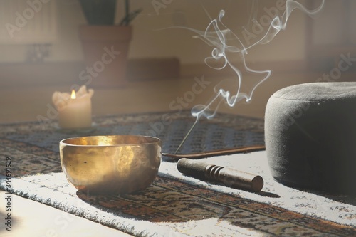 meditation room with singing bowl, incense stick, smoke, pillow and candle