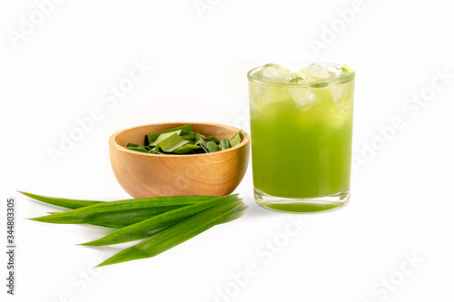 Close up Fresh pandan juice in glass with sliced in wooden bowl and leaves isolated on white background.