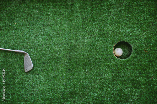 the stick lies on the field next to the hole. stick lying near golf ball. green golf sport. the stick lies to the hole.