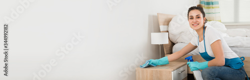 Female Housekeeper Cleaning Nightstand