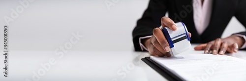 Businesswoman Putting Stamp On Documents