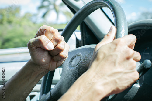 Angry driver honking and beeping the horn. Road rage.