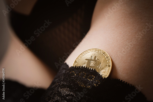 Bitcoin gold coin on in hands of sexy girl in underwear, concept shadow economy initial world prostitution