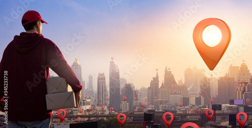 Delivery man holding parcel boxes on map pin location. Fast and free delivery transport. Online Shopping and Express delivery Concept. Copy space.