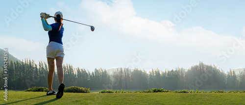 Golfer sport course golf ball fairway. People lifestyle woman playing game golf tee of on the green grass sunset background. Asia female player game shot in summer. copy space and banner