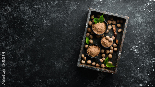 Whole nutmeg on black stone background. Spices. Free space for your text. Top view.