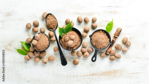 Ground nutmeg in bowls on a white background. Indian spices.