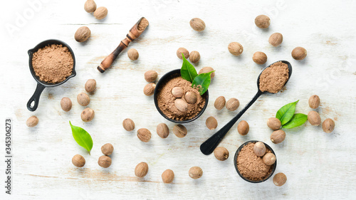 Ground nutmeg in bowls on a white background. Indian spices.