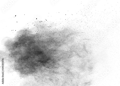 Black powder explosion on white background.Black dust particles splash.