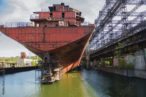 Rusty, abandoned ship under construction, unfinished ship at the factory.
