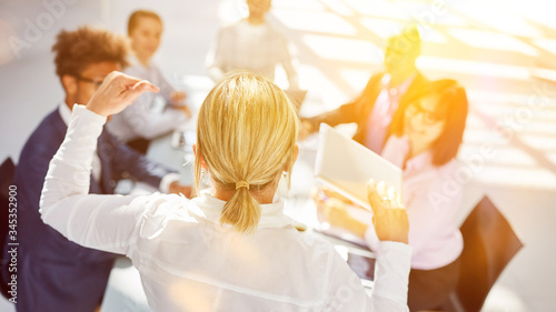 Frau als Motivationstrainer vor Business Team im Büro