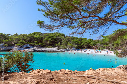 View of the famous beach Cala Turqueta. (Focus on foreground, people on the beach in blur). Menorca, Balearic islands, Spain