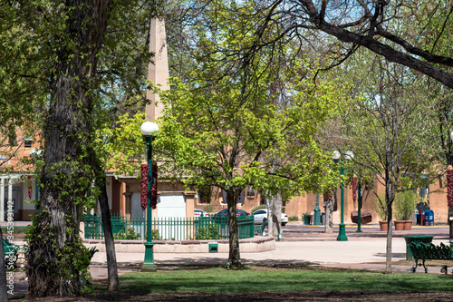 Historic obelisk, trees, and lampposts at Santa Fe Plaza in New Mexico
