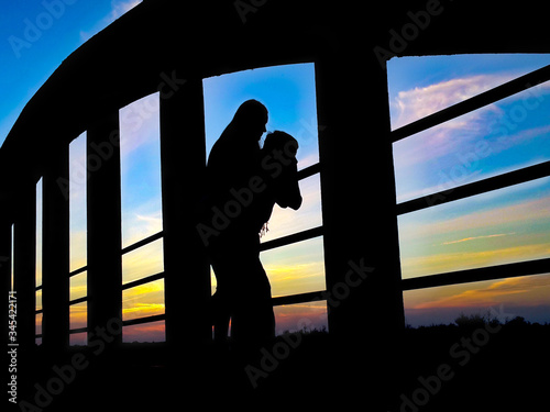 young people watching the sunset from a bridge