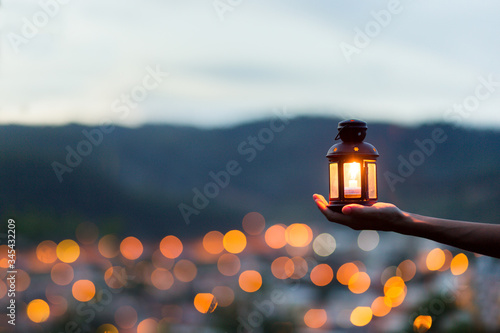 Moroccan lantern lit with city lights in the background