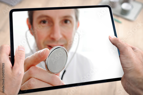 Docteur médecin en téléconsultation avec tablette et main du patient à domicile