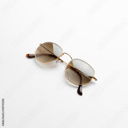 Gold frame hipster men classy sunglasses on white background isolatedwith shadow and reflection.