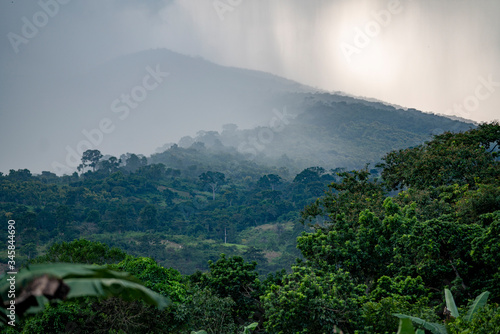 Rain squalls drench a mountain side in the jungles of tropical West Africa in Ghana.