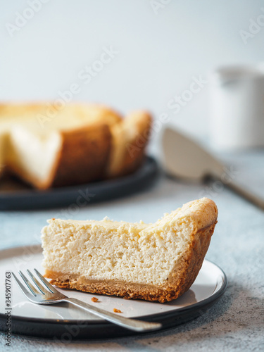 Plate with piece of cheesecake on tabletop. Classic homemade cheesecake with Shallow DOF. Vertical. Copy space for text.