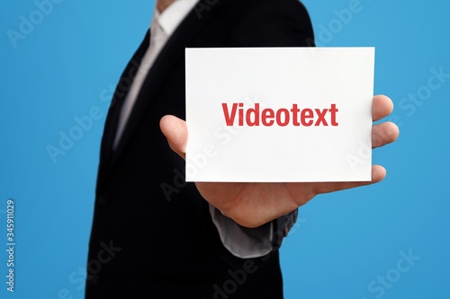 Videotext. Geschäftsmann im Anzug hält Karte in die Kamera. Der Begriff Videotext steht im Schild. Symbol für Business, Finanzen, Statistik, Analyse, Wirtschaft