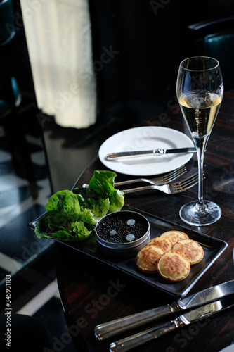 Black caviar served with blinis and champagne in the luxury restaurant