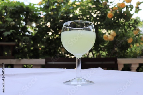 Verre de pastis mélangé avec de l'eau dans un verre rond transparent sur une nappe blanche - Département du Rhône - France