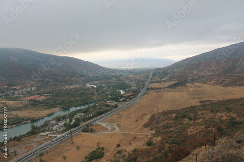 view overview from the city of Vardzia city of Queen Tamara Georgia high mountain and river at the foot in cloudy weather in fog or haze