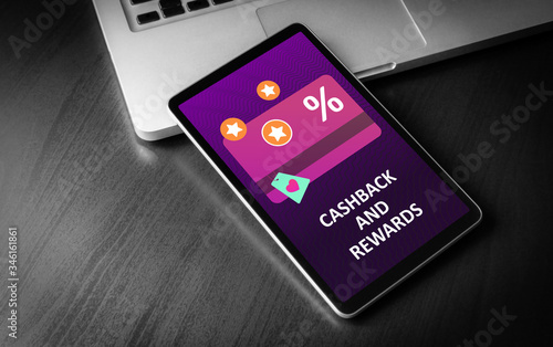 Cashback and Rewards - loyalty program and retail customer money refund service concept. Tablet PC lying on a wooden table with discount card with rewarding marketing points on the screen. 