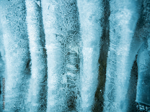 Blue ice background. Ice stalactites stalagmites. The ice of lake Baikal