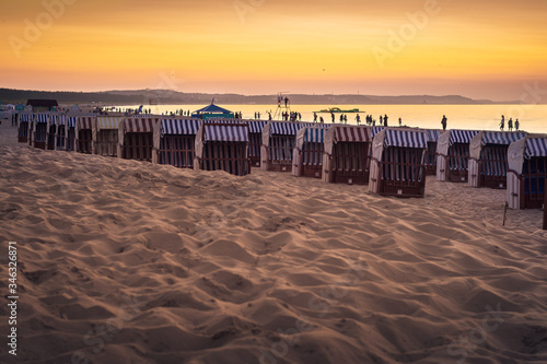 Piaszczysta plaża z koszami plażowymi nad morzem Bałtyckim o zachodzie słońca